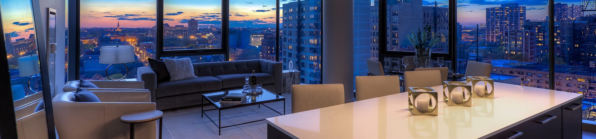 Sunset city view of Chicago through the kitchen and living room of a unit with floor to ceiling windows