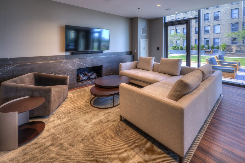 Intimate lounge with tan sectional couch, tv, and fireplace