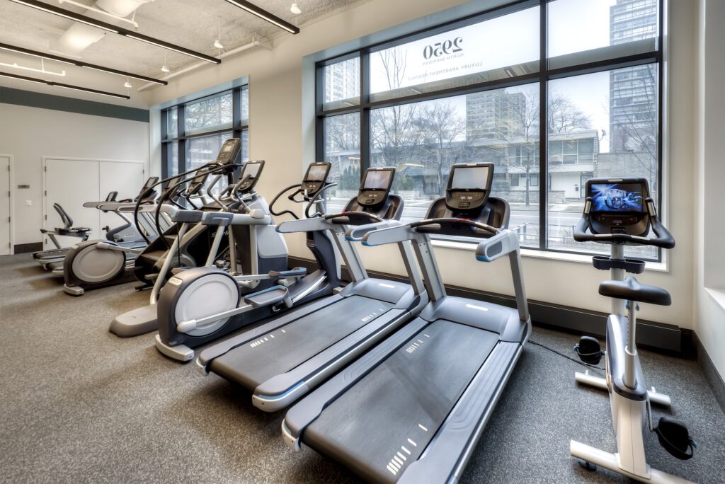 Cardio section of the 2950 N Sheridan fitness center with three treadmills, a bike, and elliptical machines