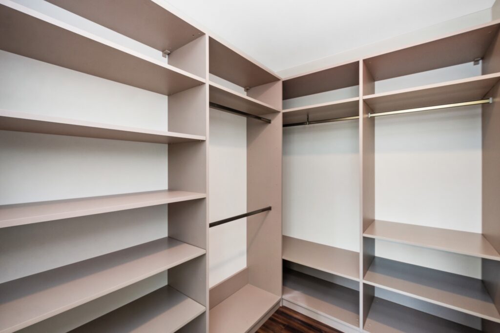 View of empty tan custom walk-in closet