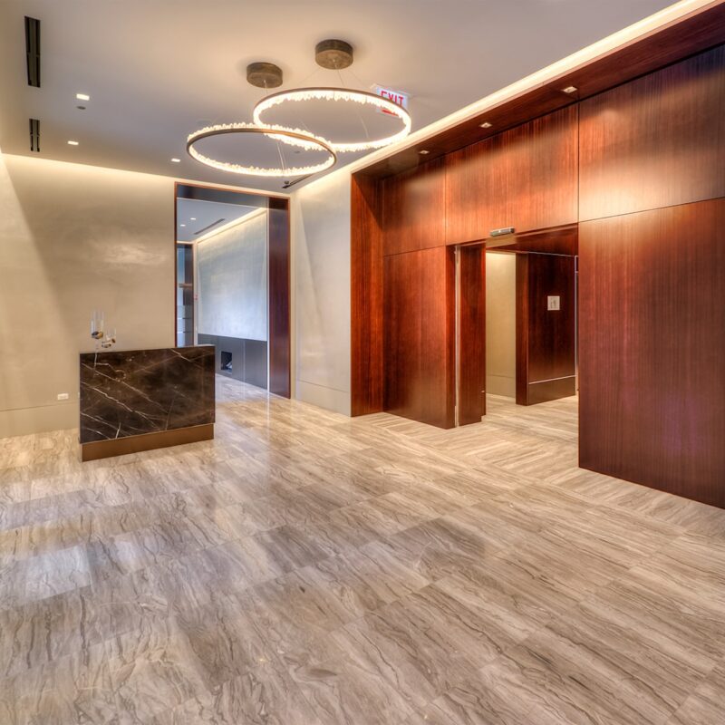 2950 N Sheridan Lobby marble floors, circular pendant lighting and dark wood walls